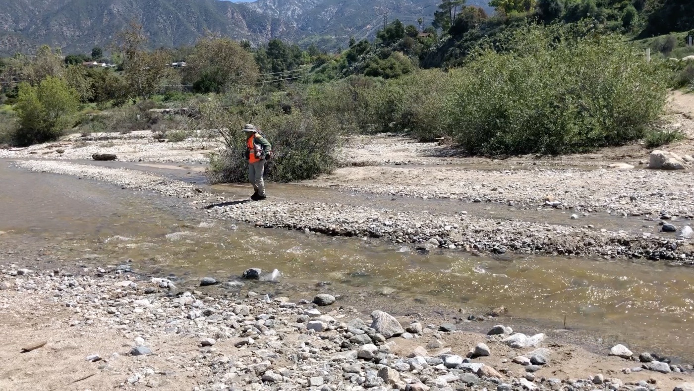 Two environmental professionals working in a mountain stream